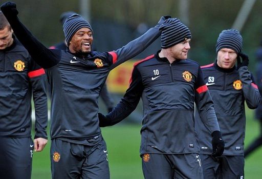 Manchester United's Patrice Evra (L) and Wayne Rooney (2nd R), pictured during a training session, on December 4, 2012